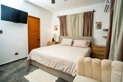 a bedroom with a bed and a tv and a couch at A solo 5 minutos caminando del Puerto de Cruceros de La Romana Perfecto para trabajo remoto y descanso prolongado in La Romana