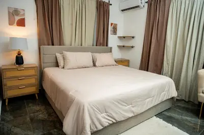 a bedroom with a bed with white sheets and a lamp at A solo 5 minutos caminando del Puerto de Cruceros de La Romana Perfecto para trabajo remoto y descanso prolongado in La Romana