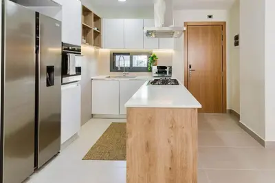 a kitchen with a stainless steel refrigerator and white cabinets at High-end 2BR w/Private Pool + BBQ + Steps to Beach in Punta Cana