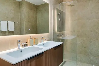 a bathroom with a sink and a glass shower at High-end 2BR w/Private Pool + BBQ + Steps to Beach in Punta Cana