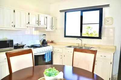 a kitchen with a table and a sink and a stove at Cozy apartment - steps from Playa Costambar in San Felipe de Puerto Plata