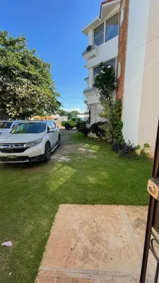 a car parked in a yard next to a building at Cozy apartment - steps from Playa Costambar in San Felipe de Puerto Plata