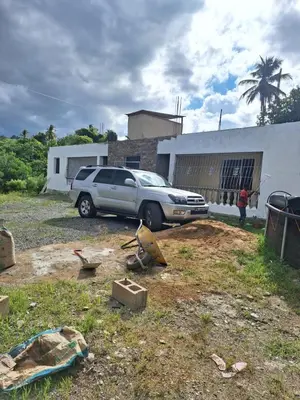 a car parked in a yard next to a building at Caribbean Corner in Jarabacoa