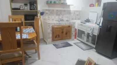 a small kitchen with a table and a refrigerator at The Colonial Corner in Colorado