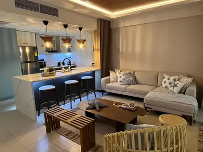 a living room and kitchen with a couch and a table at Las Olas Apartment, Juan Dolio in Guayacanes