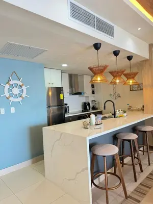 a kitchen with a counter and stools in it at Las Olas Apartment, Juan Dolio in Guayacanes