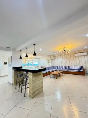 a large room with a bar and some chairs at Las Olas Apartment, Juan Dolio in Guayacanes