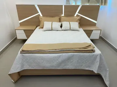 a bedroom with a large bed with a wooden headboard at Apartment in the heart of Santiago in Santiago de los Caballeros