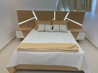 a bed with a wooden headboard in a room at Apartment in the heart of Santiago in Santiago de los Caballeros