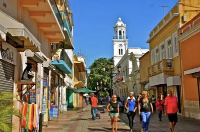 a group of people walking down a street with a clock tower at Colonial Home with Private Terrace and Jacuzzi in Santo Domingo