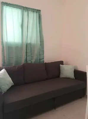 a couch with two pillows sitting in front of a window at Private studio apartment with eat in kitchen in Bayahibe