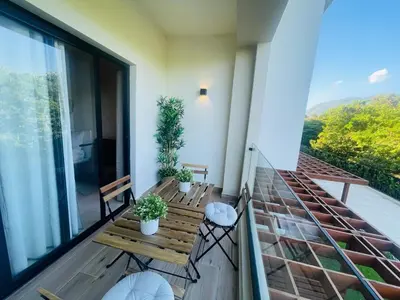 a balcony with a wooden bench and plants on it at Modern 2 Queen Beds Apartment with Garden View in Puerto Plata
