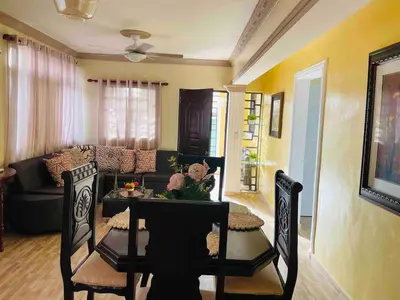 a living room with a table and chairs and a couch at Apt 2 Bedrooms a Pasos del Malecon y la Playa in San Felipe de Puerto Plata