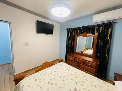 a bedroom with a bed and a dresser and a mirror at impecable 2 Bedroom Apartment Steps from the Pier in San Felipe de Puerto Plata