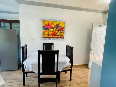 a room with a table and chairs and a painting on the wall at impecable 2 Bedroom Apartment Steps from the Pier in San Felipe de Puerto Plata