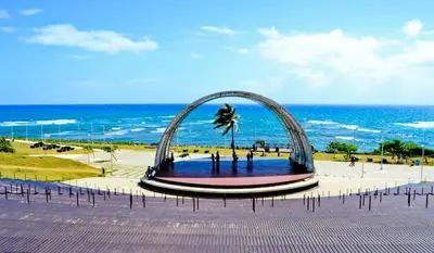 a sculpture of a palm tree in front of the ocean at impecable 2 Bedroom Apartment Steps from the Pier in San Felipe de Puerto Plata