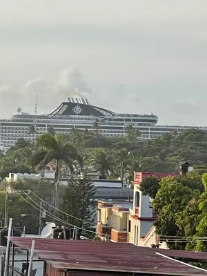 a large cruise ship in the background of a city at Luxurious 1BR apartment with ocean and mountain views, central in San Felipe de Puerto Plata