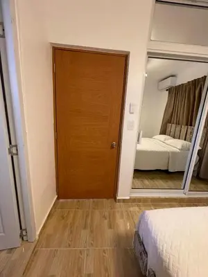 a door to a bedroom with a bed and a mirror at Luxurious 1BR apartment with ocean and mountain views, central in San Felipe de Puerto Plata