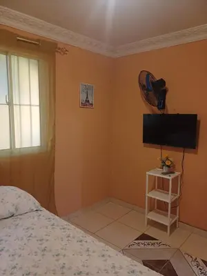 a bedroom with a bed and a flat screen tv at Dona Beba Guesthouse in La Caleta