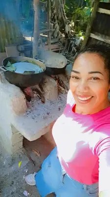 a woman is sitting in front of a stove at las taranas villa tropical