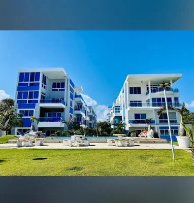 two tall apartment buildings next to a swimming pool at Luxury Cabarete East Condominiums in Cabarete