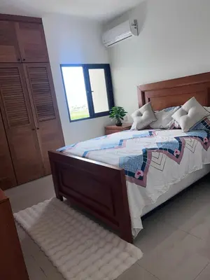 a bedroom with a large bed and a window at jardines de caleta in La Romana