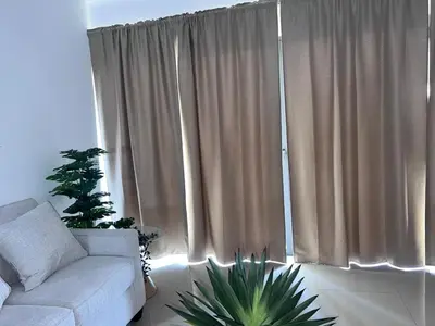 a living room with a couch and a large window at jardines de caleta in La Romana