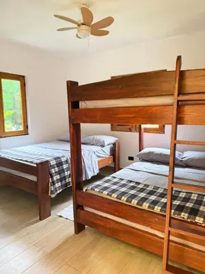 a bedroom with two bunk beds and a ceiling fan at Villa refugio de paz in Bayaguana