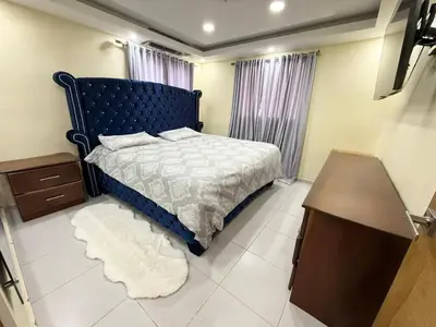 a bedroom with a blue bed and a wooden table at Villa San Pedro in San Pedro de Macorís