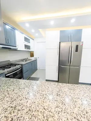 a kitchen with white cabinets and a refrigerator at Encanto - La Romana near Caleta beach in La Romana