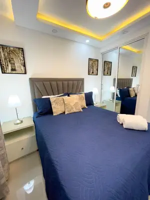 a bedroom with a large bed with blue sheets and pillows at Encanto - La Romana near Caleta beach in La Romana