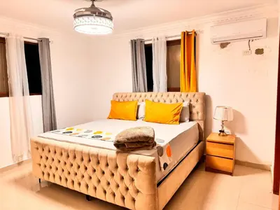 a bedroom with a large tufted bed with yellow pillows at Exclusive Huge and Lovely 4 bedrooms and 3 bathrooms apartments in Santiago close to all funs in Santiago de los Caballeros