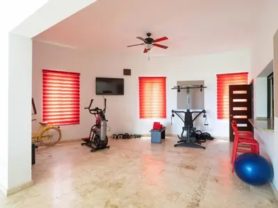 a gym with bikes and exercise equipment in a room at Villa Emoción Del Mar - Beachfront Luxury Villa