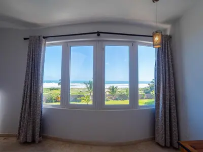 a room with a window with a view of the ocean at Villa Emoción Del Mar - Beachfront Luxury Villa