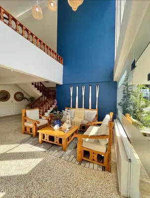 a living room with wooden furniture and a blue wall at Hotel Montesilva in Puerto Plata