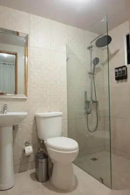 a bathroom with a toilet and a glass shower at Rustic Charm, Apartment in the heart of Santiago in Santiago de los Caballeros
