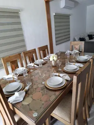 a wooden table with plates and glasses on it at Villa with Pool Terrace and 3 minutes to the beach in Puerto Plata