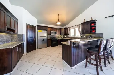 a kitchen with wooden cabinets and a counter top at 6BR, Jacuzzi, Ocean View, Solar Backup Power in Sosúa