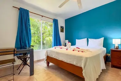 a bedroom with a bed with blue walls and a desk at Renaissance Residence Cabarete in Cabarete