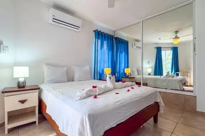 a bedroom with a large white bed with a mirror at Renaissance Residence Cabarete in Cabarete