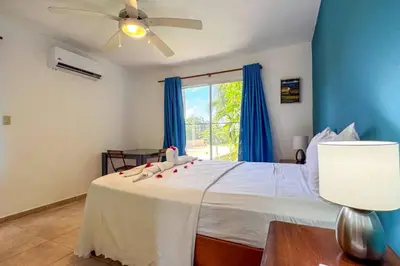 a bedroom with a white bed with a ceiling fan at Renaissance Residence Cabarete in Cabarete