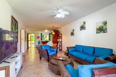 a living room with blue couches and a flat screen tv at Renaissance Residence Cabarete in Cabarete