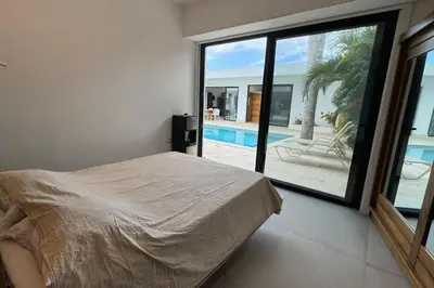 a bedroom with a bed and a view of a pool at 5 Bedroom Villa With BBQ and Washer in Las Terrenas