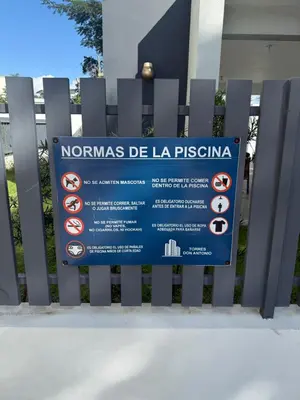 a sign on a fence in front of a building at Luxurious Apartment in Santiago de los Caballeros