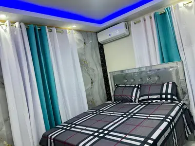 a bedroom with a bed with green and white curtains at Moderna casa cerca del aeropuerto SDQ y de mi rent cars in La Caleta