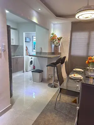 a kitchen and living room with a table and chairs at Cozy Santo Domingo Apartment in San Isidro in Juan López