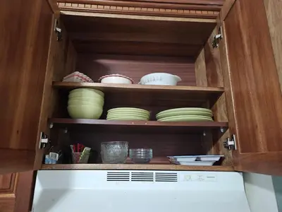 a cabinet filled with bowls and plates in a kitchen at Garden II in Boca Chica