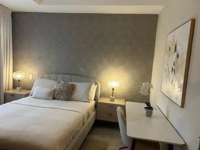 a bedroom with a bed and a desk with two lamps at REFA - 404 · Luxury 1BR Suite in Piantini | Modern • Pool • Gym in Santo Domingo