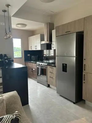 a kitchen with a stainless steel refrigerator and cabinets at REFA - 404 · Luxury 1BR Suite in Piantini | Modern • Pool • Gym in Santo Domingo