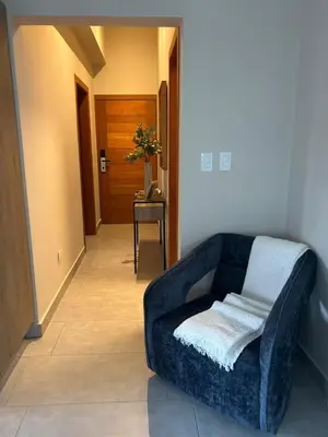 a living room with a blue couch and a table at REFA - 404 · Luxury 1BR Suite in Piantini | Modern • Pool • Gym in Santo Domingo